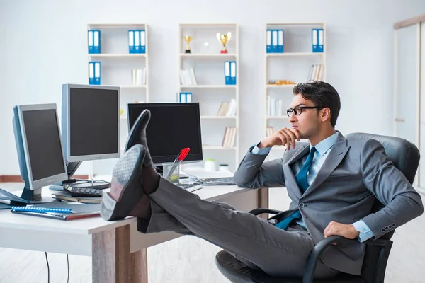 Empresario sentado frente a muchas pantallas — Foto de Stock