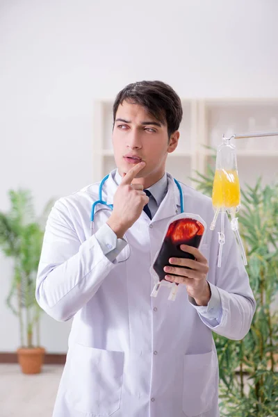 Doctor with bag of blood plasma in hospital