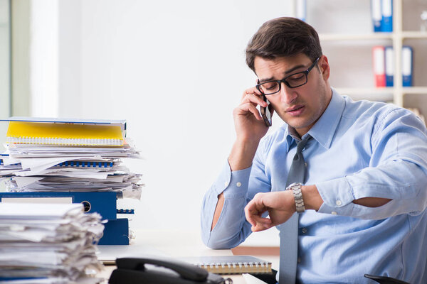 Extremely busy businessman working in office