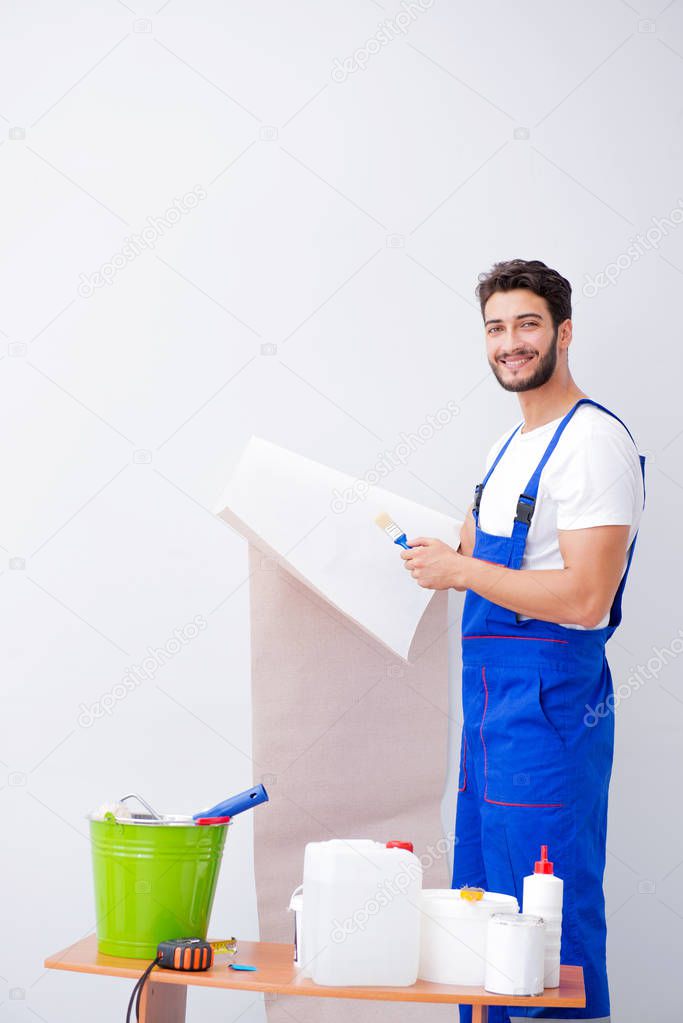 Worker working on wallpaper during refurbishment