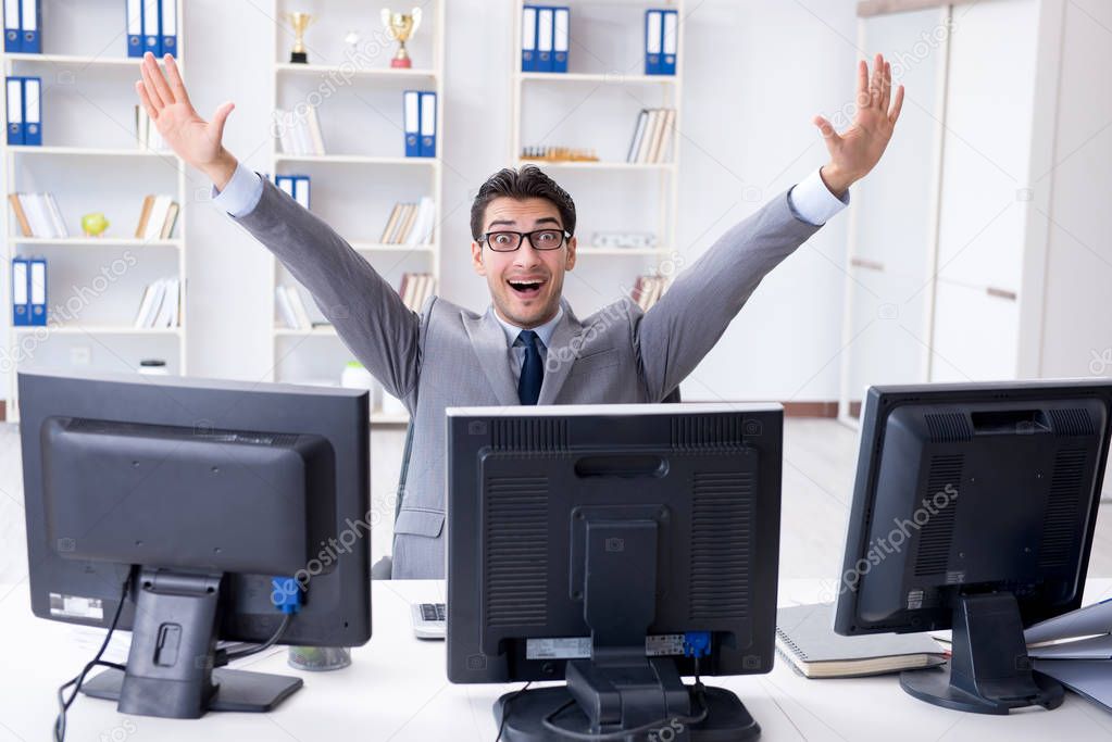 Businessman sitting in front of many screens