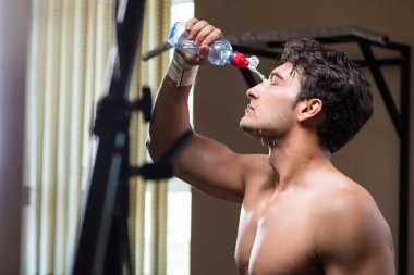 Spor salonunda su içen susamış bir adam.