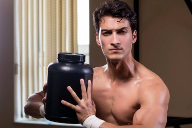 Spor salonunda besin takviyesi olan bir adam.