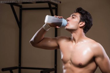 Spor salonunda besin takviyesi olan bir adam.