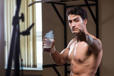 Spor salonunda besin takviyesi olan bir adam.