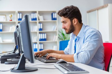 Birçok ekranın önünde oturan bir iş adamı