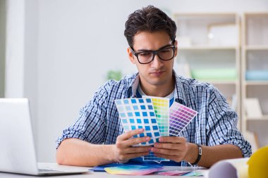 Genç tasarımcı yeni proje üzerinde çalışıyor ve renkleri seçiyor