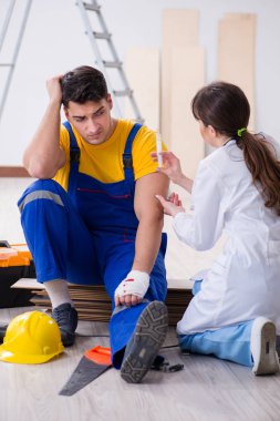 Yaralı işçiye doktor yardım ediyor.