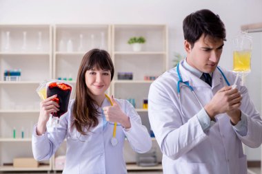 İki doktor plazma ve kan naklini tartışıyor.