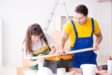 Ahşap atölyesinde kadın marangozluk ipuçlarını açıklayan adam