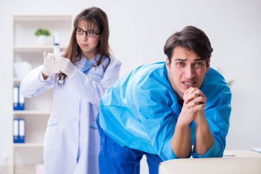 Komik adam şırınga iğnesine hazırlanıyor.