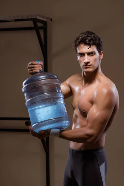 Muskularny rozdarty mężczyzna z dużą butelką wody — Zdjęcie stockowe
