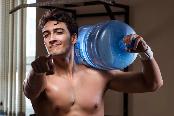 Muskularny rozdarty mężczyzna z dużą butelką wody — Zdjęcie stockowe