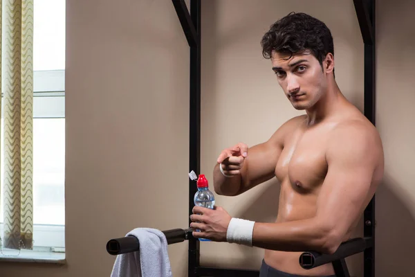 Hombre sediento bebiendo agua en el gimnasio deportivo — Foto de Stock