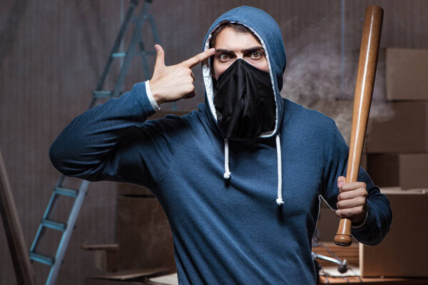 Хулиган с летучей мышью в темной комнате