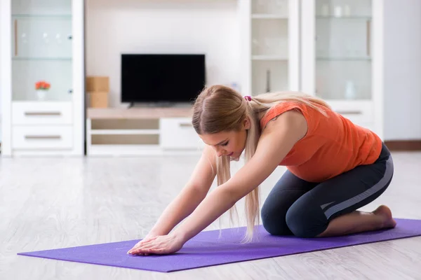 Těhotná žena dělá sportovní cvičení doma — Stock fotografie