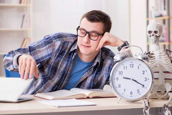 Estudante e esqueleto se preparando para os exames escolares — Fotografia de Stock