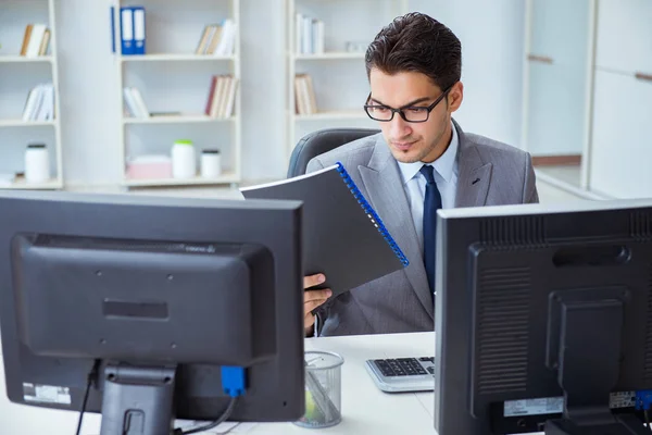 Empresario sentado frente a muchas pantallas — Foto de Stock