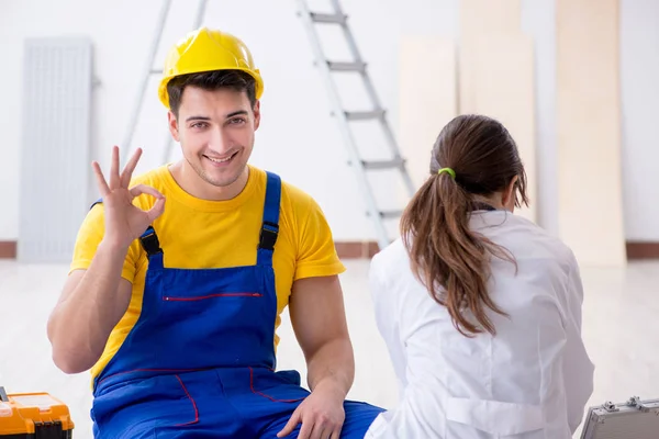 Doctor helping injured worker at construction site — Stock Photo, Image