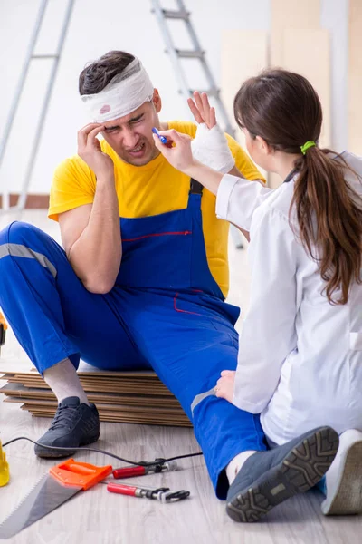 Lavoratore con testa ferita e medico — Foto Stock