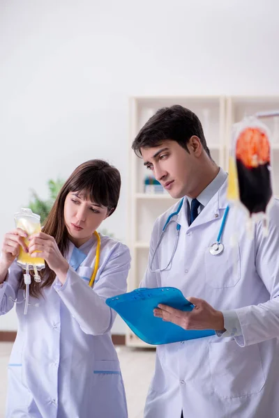 Dos doctores discutiendo plasma y transfusión de sangre — Foto de Stock