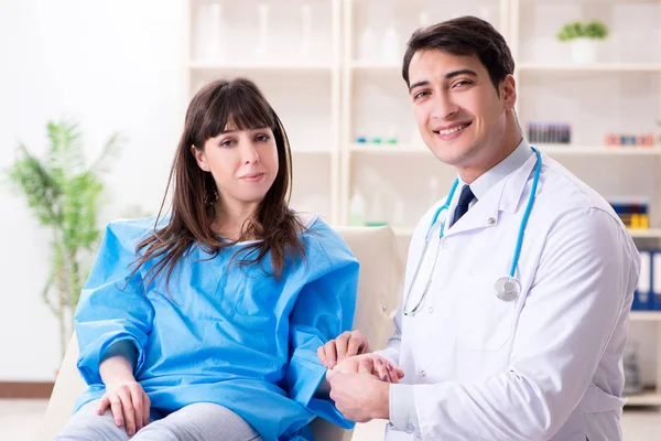 Male doctor checking up female patient in hospital — Stock Photo, Image