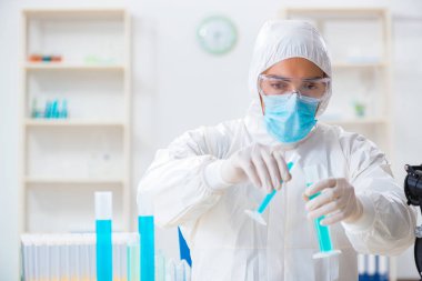 Laboratuvarda kimyasallar üzerinde çalışan genç bir kimyager.