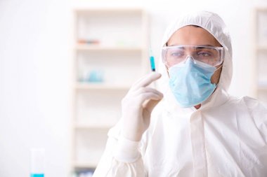 Laboratuvarda kimyasallar üzerinde çalışan genç bir kimyager.