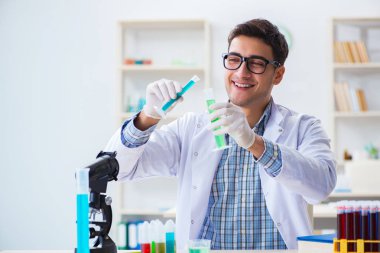 Laboratuvarda kimyasallar üzerinde çalışan genç bir kimyager.