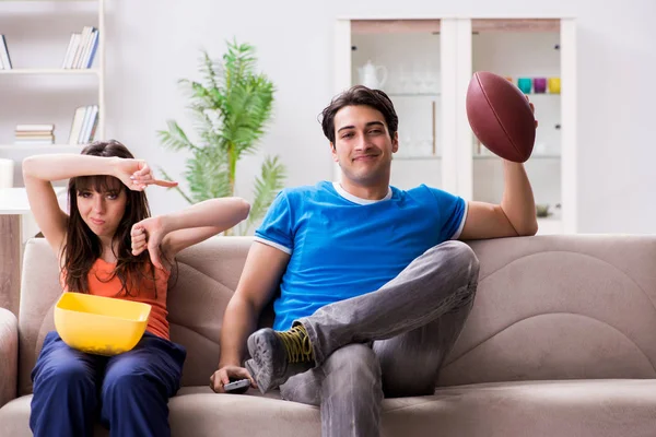 Egy férfi amerikai focit néz a feleségével. — Stock Fotó