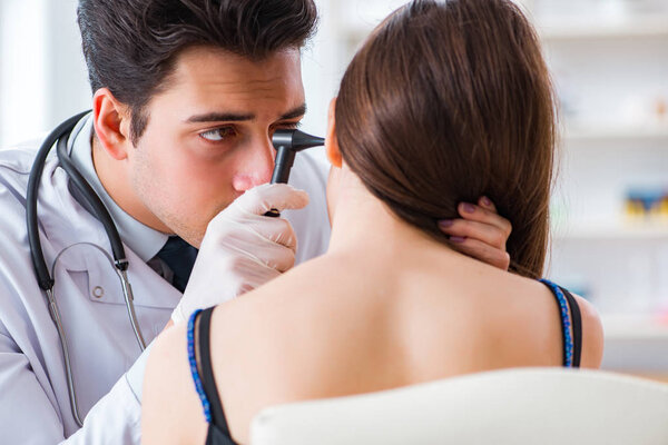 Doctor checking patients ear during medical examination