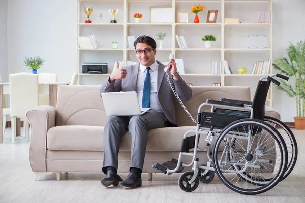 Uomo d'affari disabile sulla sedia a rotelle che lavora a casa — Foto Stock