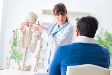 Doktor boynu yaralanan hastaya durumu açıklıyor.