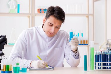 Laboratuvarda kimyasallar üzerinde çalışan genç bir kimyager.