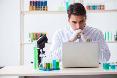 Kimya laboratuvarında deneyler yapan bir erkek öğrenci.