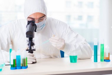 Laboratuvarda kimyasallar üzerinde çalışan genç bir kimyager.