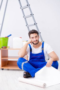 VR gözlüklü, duvar kağıdı yapıştıran bir adam.