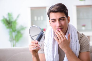 Adam evde tıraş olmaya hazırlanıyor.