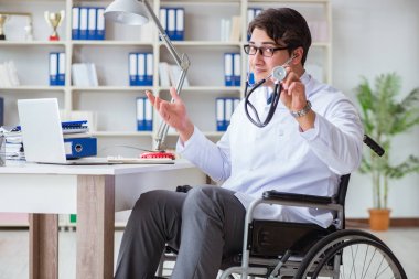 Hastanede çalışan tekerlekli sandalyedeki engelli doktor.