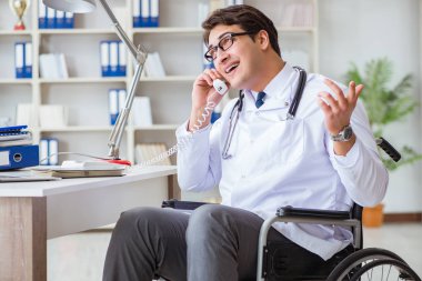 Hastanede çalışan tekerlekli sandalyedeki engelli doktor.