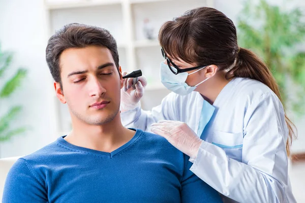 Lekarz sprawdzający uszy pacjentów podczas badania lekarskiego — Zdjęcie stockowe