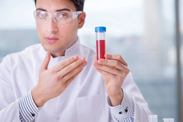 Hombre médico revisando muestras de sangre en el laboratorio — Foto de Stock