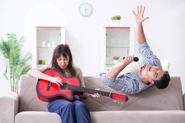 Família jovem cantando e tocando música em casa — Fotografia de Stock