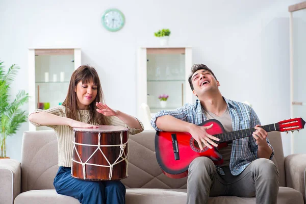Família jovem cantando e tocando música em casa — Fotografia de Stock