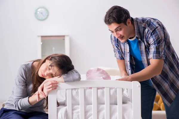 Νέοι γονείς με το νεογέννητο μωρό τους κοντά στο κρεβάτι — Φωτογραφία Αρχείου