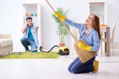 Genç bir aile evi temizliyor.