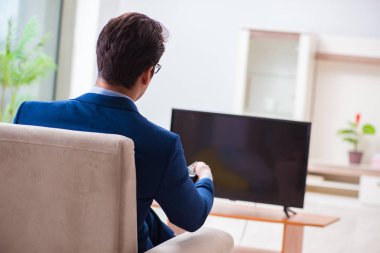 İş adamı ofiste televizyon izliyor.