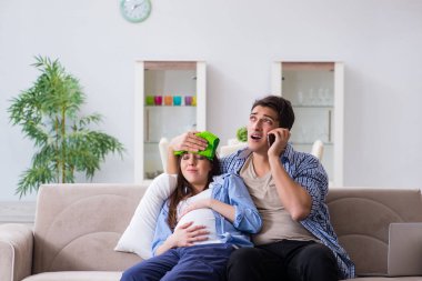 Evde kocası olan hamile bir kadın.