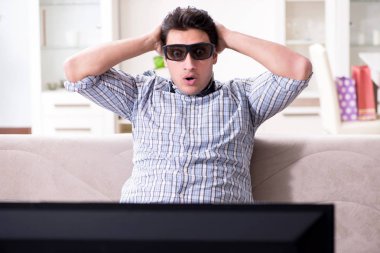 Evde 3D televizyon izleyen bir adam.