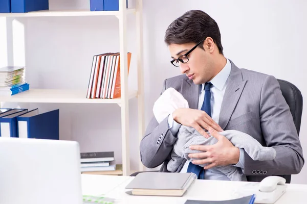 Zakenman op zoek naar pasgeboren baby in kantoor — Stockfoto